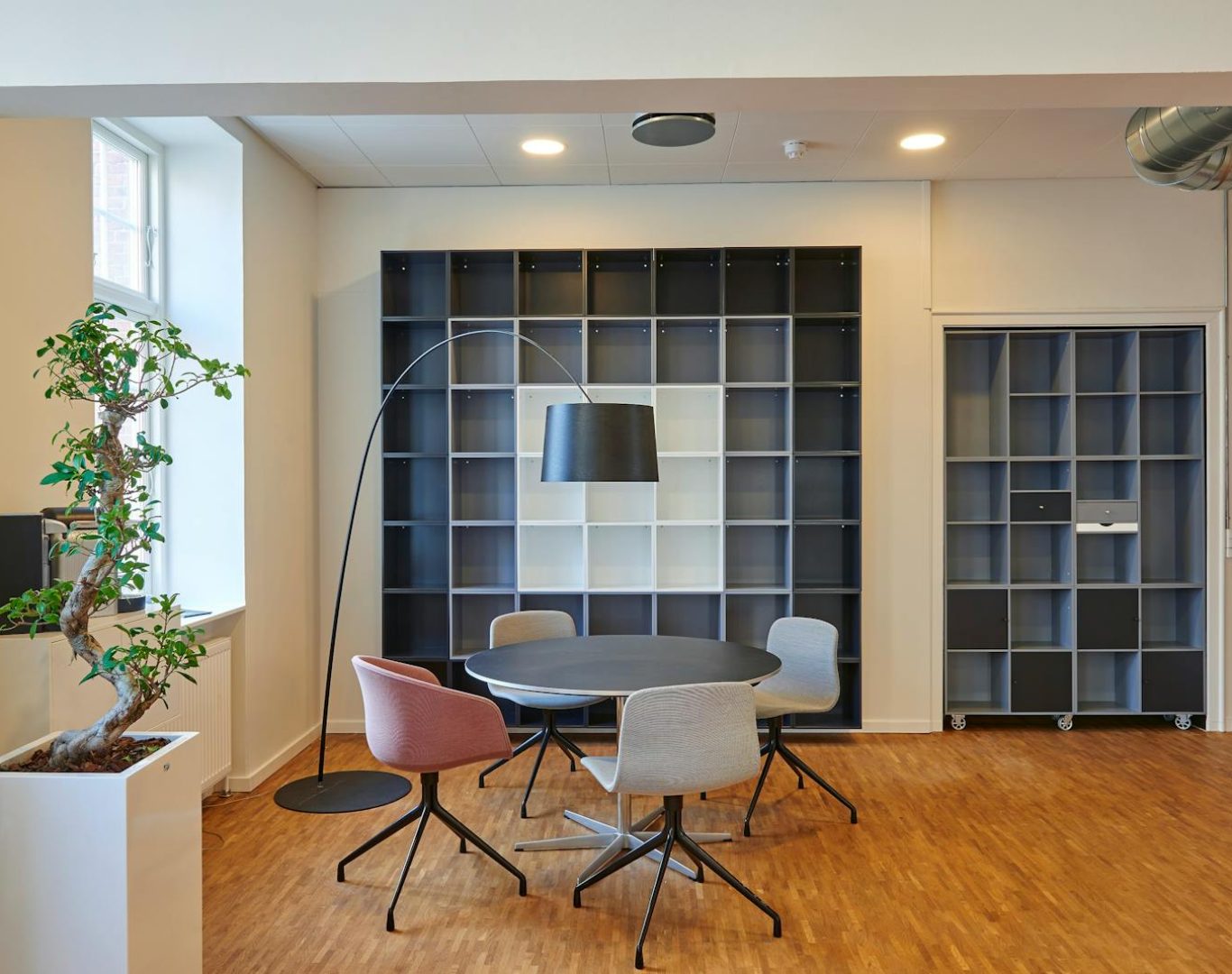 Bright and stylish office space with contemporary furniture and open shelving.