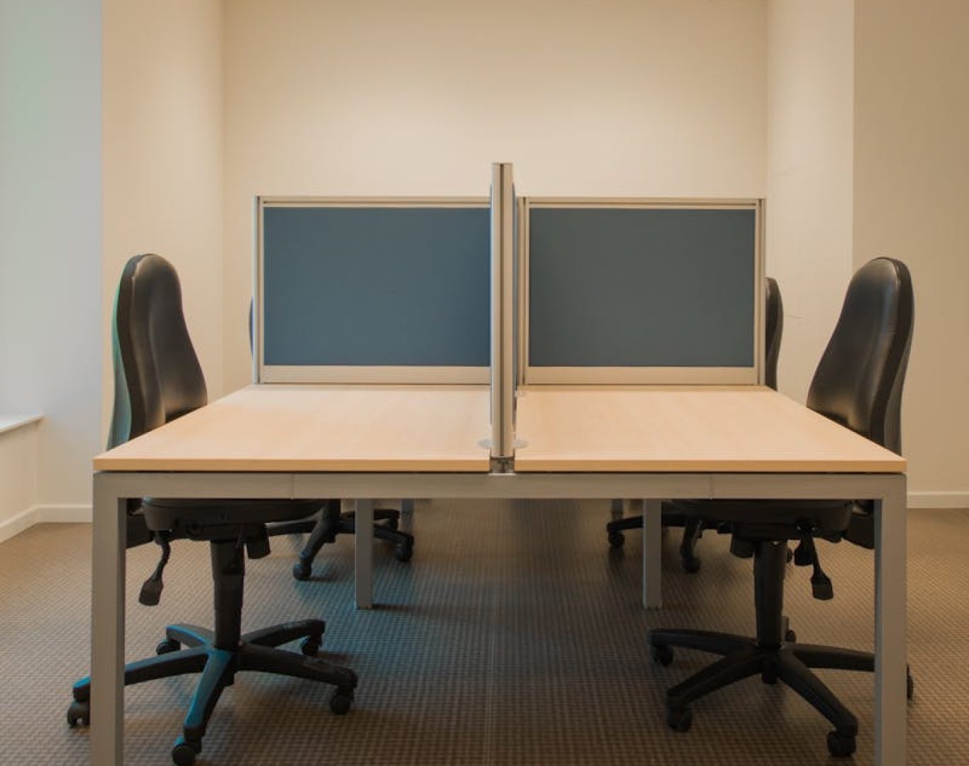 Contemporary office space featuring partitioned desks and ergonomic chairs.